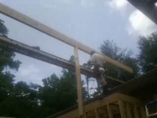 Carpenter setting a ridge beam over a new addition frame — Ice Dam Removal by Roofing Brothers in Kersey