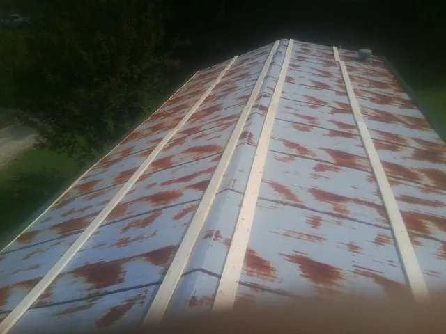 Rusted metal roof panels with new wood purlins before replacement — Storm Damage Roof Repair in Kersey by Roofing Brothers