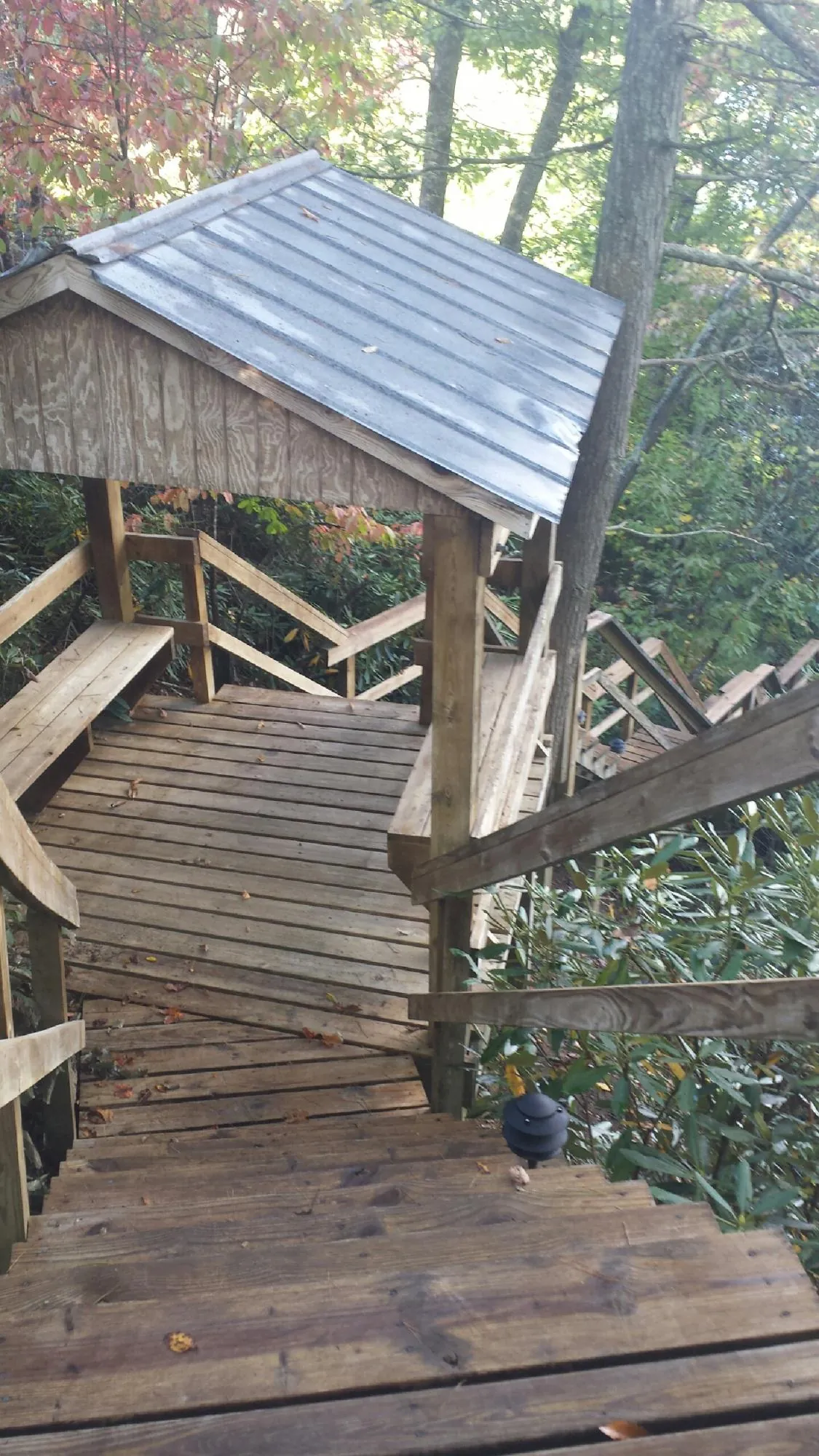 Metal roofed shelter over wooden steps on a wooded walkway — Skylight Repair & Installation work by our crew in Kersey